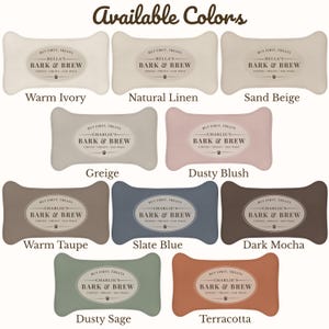 May include: A collection of ten bone-shaped pillows displayed in various colors including warm ivory, natural linen, sand beige, greige, dusty blush, warm taupe, slate blue, dark mocha, dusty sage, and terracotta, each featuring a central oval label.