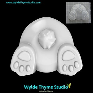 May include: White silicone mold of a bunny rabbit's bottom with two paw prints. The mold is designed for making soap, resin, or other crafts.