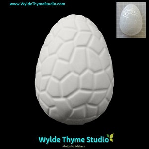 May include: White plastic mould shaped like an egg with a textured surface. The mould is designed to create a decorative egg with a textured surface.
