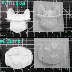 May include: Two clear plastic molds for making resin crafts. The molds are shaped like the heads of characters from the cartoon show Paw Patrol. The first mold is labeled #7 Tracker and features a white dog with a red hat. The second mold is labeled #8 Zuma and features a white dog with a blue helmet.