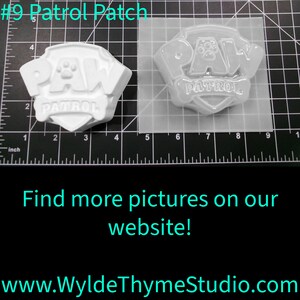 May include: A white plastic mold for making a Paw Patrol logo. The mold is 4 inches wide and 3 inches tall. The mold is on a gridded surface. The text #9 Patrol Patch is visible in the image.