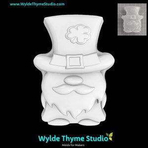 May include: White plastic mould of a leprechaun wearing a hat with a shamrock on top. The mould is for making soap, candles, or other crafts.