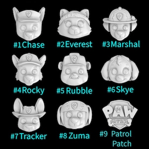 May include: Nine white Paw Patrol character heads, including Chase, Everest, Marshal, Rocky, Rubble, Skye, Tracker, Zuma, and the Paw Patrol logo. Each character has a unique design and expression.
