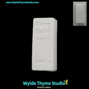 以下が含まれることがあります： 1000グラムの金塊を作るための白い長方形の型。型には「Fine Gold 999.9 1000 g」という文字が前面に刻印されています。