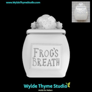 May include: A white jar with a lid, featuring the text "FROG'S BREATH" in a rectangular frame. The lid is adorned with a textured, rounded design. The image includes the website address www.WyldeThymeStudio.com.