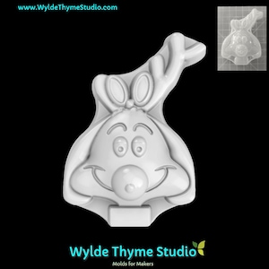 May include: White plastic mold of a cartoon reindeer with large ears and antlers. The mold is designed for making crafts or decorations.
