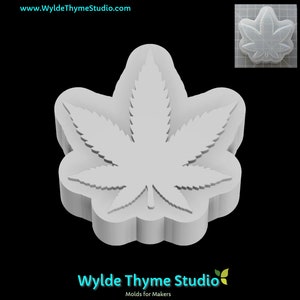 Puede incluir: Un molde de silicona blanco con forma de hoja de marihuana. El molde está diseñado para hacer manualidades de resina, jabón u otros objetos pequeños.