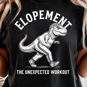 May include: Black t-shirt with a white graphic of a dinosaur in sportswear, and the word "ELOPEMENT" above it. The text "THE UNEXPECTED WORKOUT" is below the dinosaur.