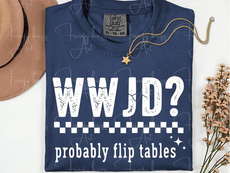 May include: Navy blue t-shirt with the text "WWJD? probably flip tables" in white. The shirt has a checkered pattern and star accents. A gold necklace with a star pendant and a brown hat are also visible.