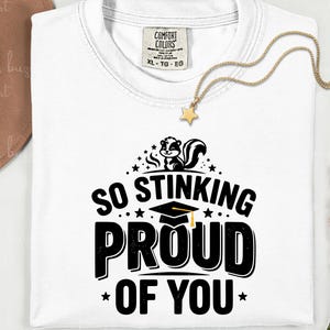 May include: A white ceramic mug with a black handle and the text "But First, Coffee" in a bold, black font. The mug is set against a blurred background, highlighting its clean design.