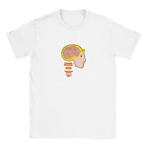 Peut inclure: T-shirt blanc avec un profil de personne et un cerveau stylisé. Le cerveau est marron et rose, avec un contour jaune. Du texte en langue étrangère est en dessous du dessin.