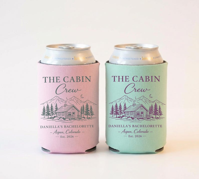 May include: Two can coolers, one pink and one mint green, each with a cabin and mountain graphic. Text on the coolers reads "THE CABIN CREW" and "DANIELLA'S BACHELORETTE - Aspen, Colorado - Est. 2026."