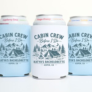 May include: Three beverage insulators with the text "CABIN CREW Before I Do" and a mountain and tent graphic. One is white, two are light blue. The text "KATYA'S BACHELORETTE ASPEN, CO" is also printed on the insulators.