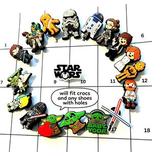 May include: A collection of Star Wars themed shoe charms featuring various characters including Yoda, Darth Vader, and Stormtroopers. The charms are arranged in a circle around a Star Wars logo and a speech bubble that reads, will fit crocs and any shoes with holes.