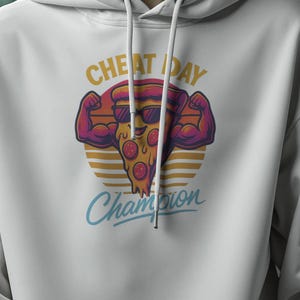 Könnte beinhalten: Weißer Kapuzenpullover mit einem Front-Grafikdesign einer Pizza, die ihre Arme anspannt, mit den Worten "CHEAT DAY" darüber und "Champion" darunter in blauer Schrift. Das Design ist vor einem gelb-orangen gestreiften Hintergrund platziert.