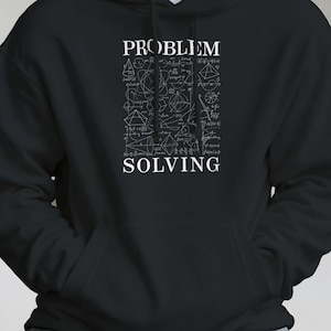 Op de afbeelding: Zwarte hoodie met de witte woorden "PROBLEM SOLVING". De hoodie heeft een afbeelding van wiskundige vergelijkingen en geometrische vormen in het wit. Het heeft een voorzak en een capuchon met trekkoord.