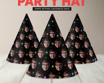 May include: Three black party hats with a repeating pattern of a person's face, glasses, and a smiling expression. The hats are decorated with colorful stars and are cone-shaped with a white string base. The text "PARTY HAT" is at the top.