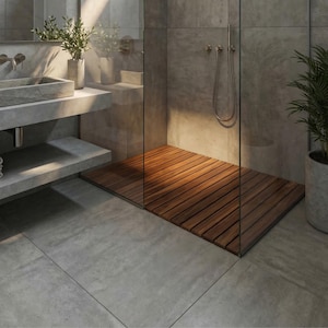 May include: A bathroom interior featuring a concrete sink basin mounted on a floating concrete shelf, a glass-enclosed shower area with a slatted wooden floor, a wall-mounted shower head with a hose, and two potted green plants.