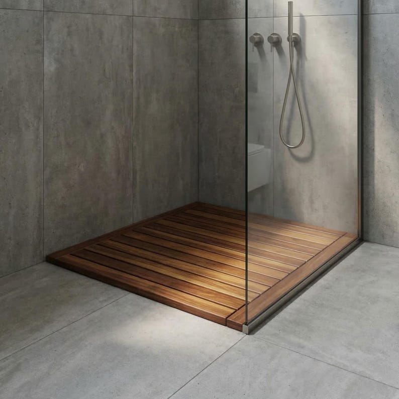 May include: A modern shower stall with a wooden floor. The floor is made of horizontal wooden planks, creating a warm contrast against the gray tiled walls and floor. A glass door encloses the shower area, with a silver shower head and fixtures.