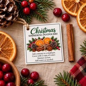 Op de afbeelding: Een vierkant wit label met een jute touwtje met de tekst Christmas SIMMERING POTPOURRI en instructies om de inhoud aan een kleine pan toe te voegen, te bedekken met 2 kopjes water, op laag vuur te laten sudderen en water toe te voegen.