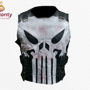 Op de afbeelding: Een wit en zwart vest met een schedelontwerp. Het vest heeft zwarte accenten, waaronder zakken en riemen. Het schedelmotief is prominent aanwezig op de voorkant. Het vest is van Monty Jackets.