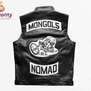 Könnte beinhalten: Schwarze Lederweste mit weißen Aufnähern. Die Weste zeigt das Wort "MONGOLS" auf dem oberen Rücken, einen Motorradaufnäher und das Wort "NOMAD" unten. Die Weste hat einen klassischen Biker-Stil.