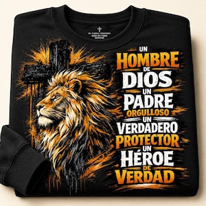 May include: A black long-sleeve sweatshirt featuring a graphic of a lion's head and a cross. The text reads: UN HOMBRE DE DIOS UN PADRE ORGULLOSO UN VERDADERO PROTECTOR UN HÉROE DE VERDAD. The design uses orange, yellow, and white colors on black fabric.