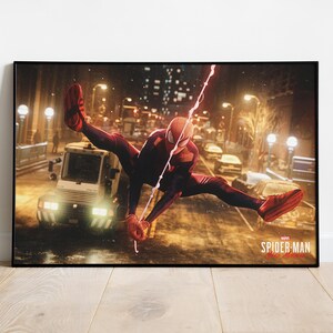 May include: A framed print featuring Spider-Man in a dynamic pose, swinging through a city street. The superhero is clad in a red and black suit, with a web strand extending across the image. The title "Spider-Man Miles Morales" is visible.