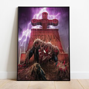 May include: A framed comic book art print featuring Spider-Man rising from a grave. The tombstone reads "Here Lies Spider-Man" with a cross-shaped top. The artwork is set against a purple stormy sky with lightning.