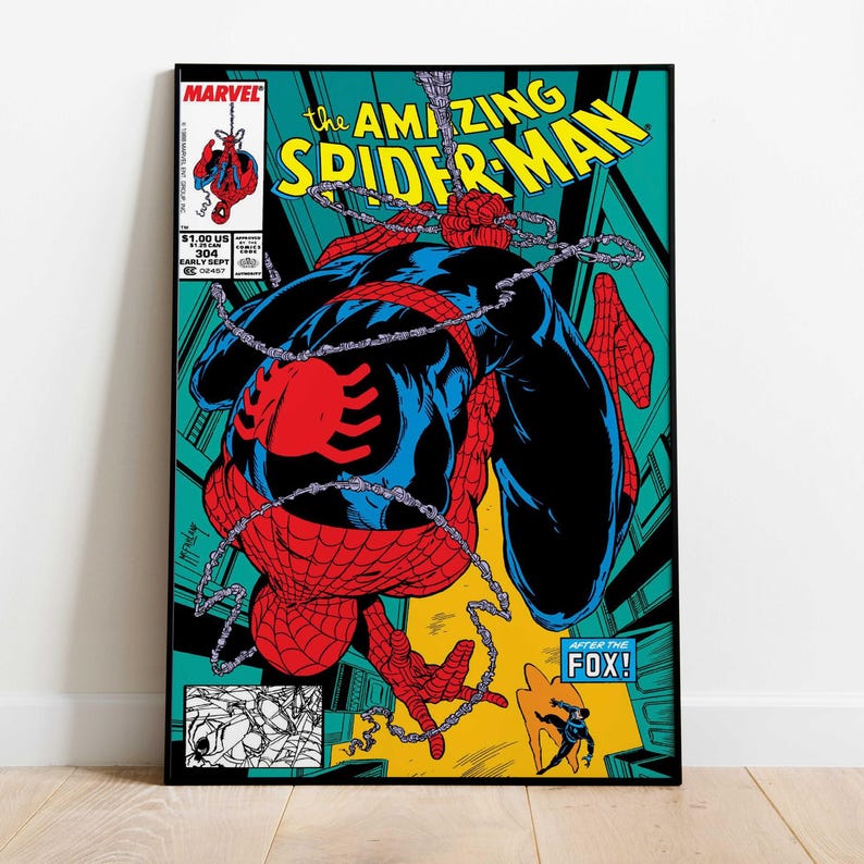 May include: A framed comic book cover of Spider-Man. The image shows Spider-Man in a red and blue suit, with the title "The Amazing Spider-Man" in yellow. The Marvel logo is visible. The comic is set against a teal background.