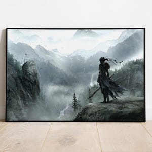 Puede incluir: Impresión artística enmarcada que representa una escena de fantasía. Una figura se encuentra en un acantilado con vistas a una cordillera brumosa. La obra de arte es predominantemente en escala de grises con toques de azul y verde.