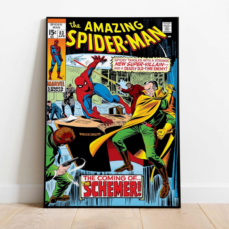 May include: A framed comic book cover of The Amazing Spider-Man. The cover features Spider-Man in a red and blue suit, battling a villain in a yellow cape and green suit. Text includes "The Coming of... The Schemer!"