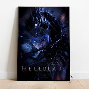Puede incluir: Póster enmarcado con un personaje del videojuego Hellblade. El personaje tiene pintura facial azul y una corona. El póster tiene una combinación de colores oscura y dramática con el título del juego en la parte inferior.