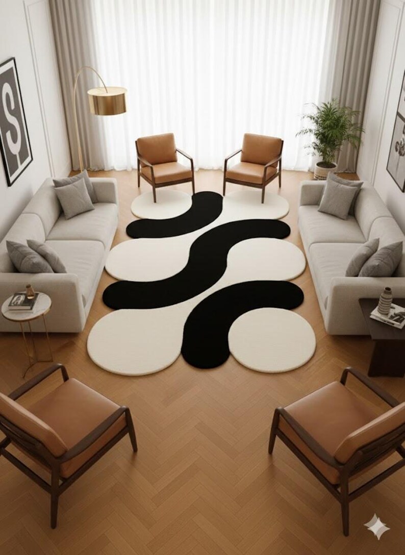 May include: A modern living room featuring a large, abstract rug with a black and white wavy design. Two matching sofas face each other, with two brown leather chairs in front of each sofa. The room has a neutral color palette with a gold floor lamp.