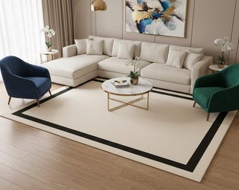 Alfombra minimalista color crema con borde negro, moderna y neutra para sala de estar.
