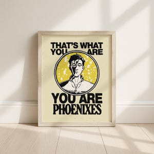 Puede incluir: Lámina artística enmarcada con el texto "THAT'S WHAT YOU ARE YOU ARE PHOENIXES". La obra presenta una ilustración en blanco y negro de una persona dentro de un círculo amarillo. El fondo es de color amarillo claro.
