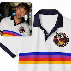 Puede incluir: Un polo blanco con cuello y puños de color azul marino oscuro. La prenda presenta tres franjas horizontales en azul, morado y amarillo en el pecho. Un parche circular en el pecho izquierdo muestra una estación espacial y el texto Project Hail.