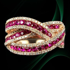 Pode incluir: Um anel de ouro rosa com um design entrelaçado. O anel é cravejado com fileiras de pedras preciosas rosa vibrantes e pedras preciosas claras menores. As pedras preciosas são definidas em um estilo pavé, criando um efeito brilhante.