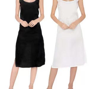 Könnte beinhalten: Gezeigt werden zwei Unterkleider, eines in Schwarz und eines in Weiß. Das schwarze Kleid hat einen Rundhalsausschnitt und einen knielangen Saum mit Seitenschlitz. Das weiße Kleid hat einen quadratischen Ausschnitt und Spaghettiträger. Beide Kleider sind aus glattem Stoff.