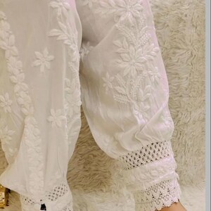 Women’s white cotton afghani pants featuring floral chikankari work