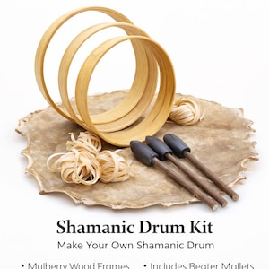 May include: A Shamanic Drum Kit with mulberry wood frames, beater mallets, and other components. The kit includes three wooden hoops, bundles of wood shavings, and three drum mallets with dark gray heads. The text reads "Shamanic Drum Kit".