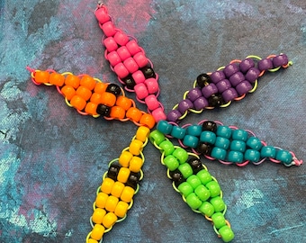 Kandi Worms enfärgade ponnypärlor på regnbågssnöre