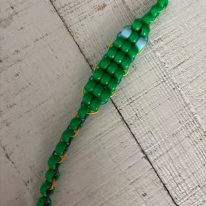 May include: A white ceramic mug with a black handle and the text "But First, Coffee" in a black, bold font. The mug is sitting on a wooden surface. The mug is approximately 4 inches tall.