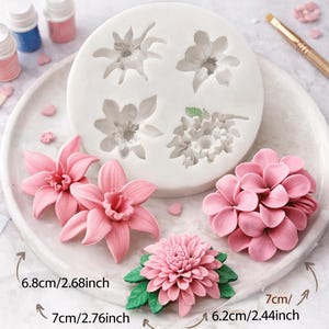 Puede incluir: Un molde de silicona blanco para flores con cuatro diseños florales detallados, junto con varios modelos de flores rosas. La imagen incluye el texto "Flower Silicone Mold" y medidas en cm: 6,8 cm, 7 cm y 6,2 cm.