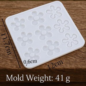 May include: A white silicone flower-shaped mold. The mold is square, measuring 4.7 inches wide, 4.6 inches long, and 0.2 inches deep. The mold has a weight of 1.4 ounces. The text "Mold Weight: 41 g" is visible.