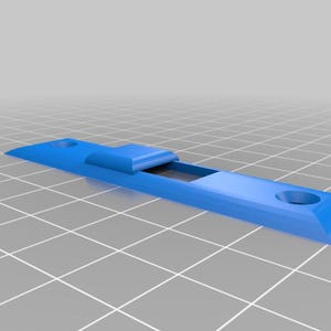 May include: A light blue, rectangular object with a raised central section and two circular holes at each end. The object has a geometric design and appears to be made of plastic or a similar material.