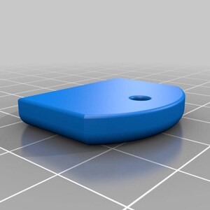 May include: A solid blue, D-shaped object with a rounded edge and a small hole near the curve. The object is set against a grid background, suggesting a 3D model or design element.