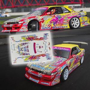 May include: A yellow, red, and pink race car with a detailed graphic design. The car has white wheels and a spoiler. A sheet of matching decals is in the foreground. Text includes "ORIGIN Labo", "555 KNUCKLE", and "CS GARAGE".