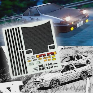 Può includere: Immagine di un'auto bianca e nera con il testo "藤原とうふ店" e "13-954". L'immagine include anche un foglio di adesivi con un design nero strutturato, forme rettangolari e lo stesso testo e numeri. Stile manga.