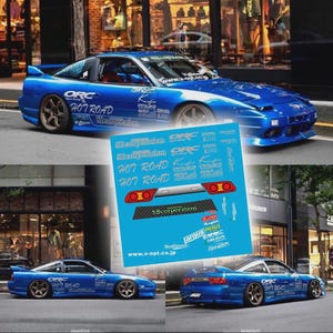 Puede incluir: Un coche deportivo azul brillante con calcomanías personalizadas, incluyendo "ORC" y "707 ROAD", se muestra. La imagen también muestra una hoja de calcomanías a juego. El coche tiene un diseño elegante con un alerón y ruedas personalizadas.